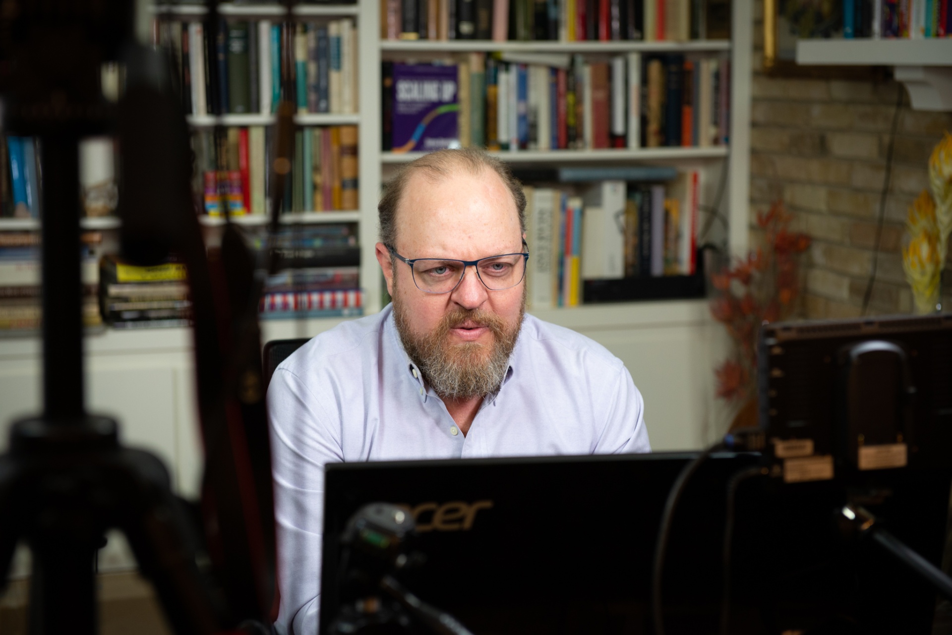 Max Kozlovsky working at his desk surrounded by leadership and business books