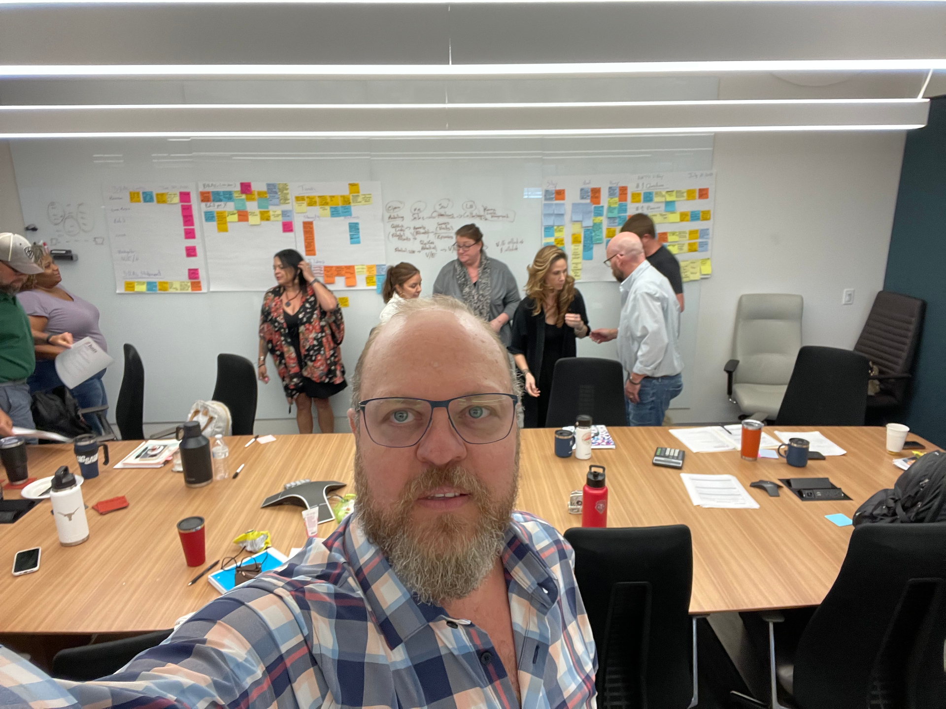 Max Kozlovsky facilitating a team strategy session with sticky-note planning walls in the background